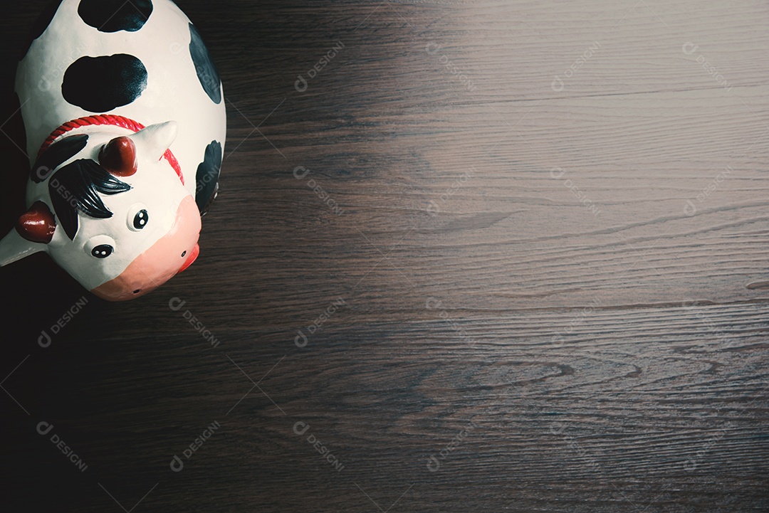 Escultura de arte de papel de vaca no chão de madeira.