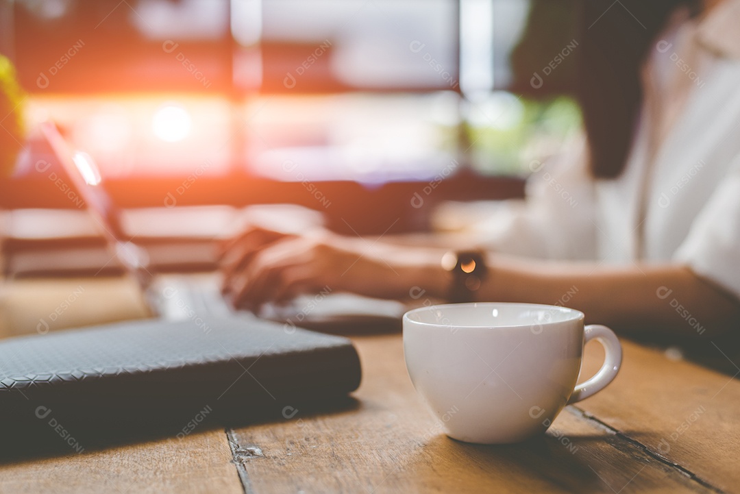 Fechar a xícara de café com a empresária trabalhando ao ar livre.