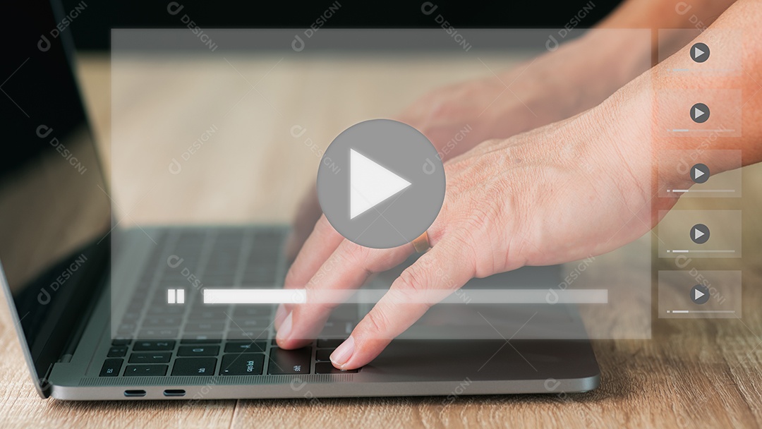 Um homem está usando um laptop em uma mesa de madeira.