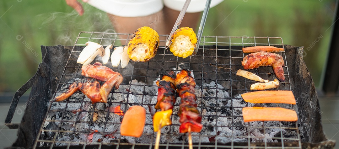 delicious grilled meat with smoke, barbecue with vegetables outdoors. Barbecue, party, lifestyle and picnic concept