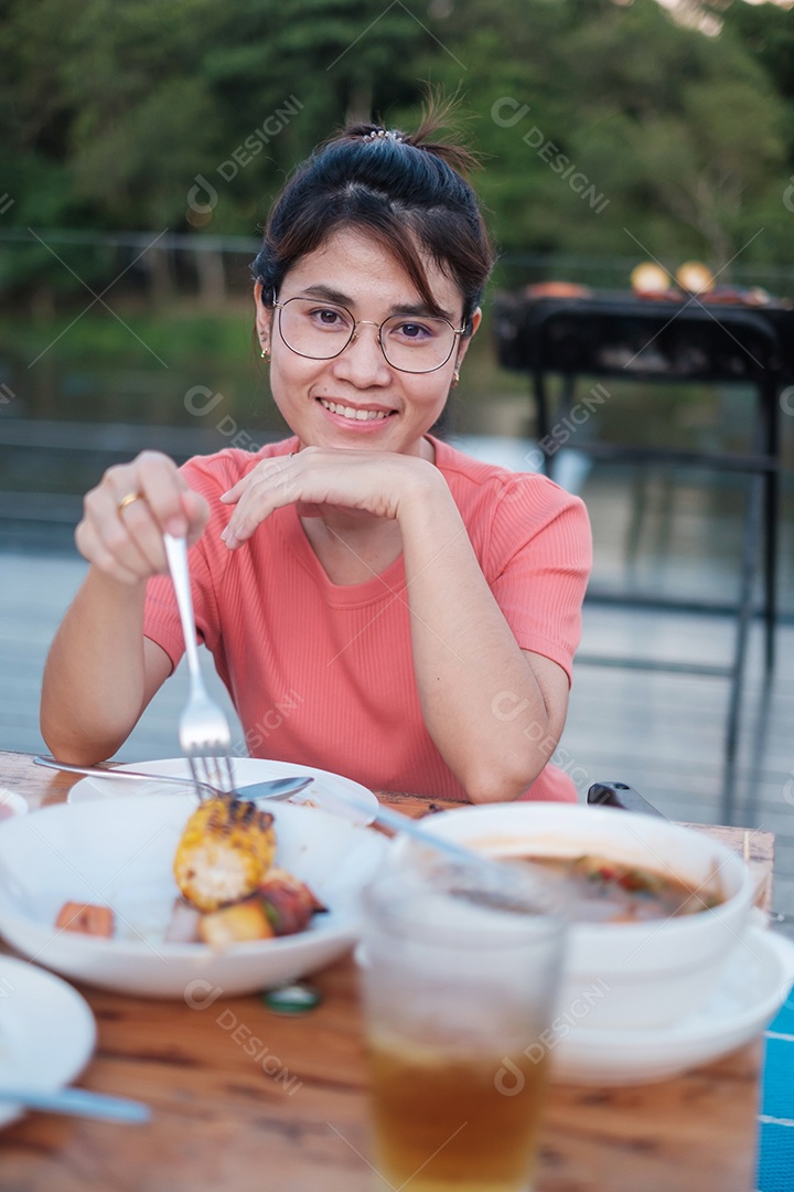 Mulher feliz jantando com deliciosas carnes grelhadas e churrasco ao ar livre. Churrasco, festa, estilo de vida e conceito de piquenique
