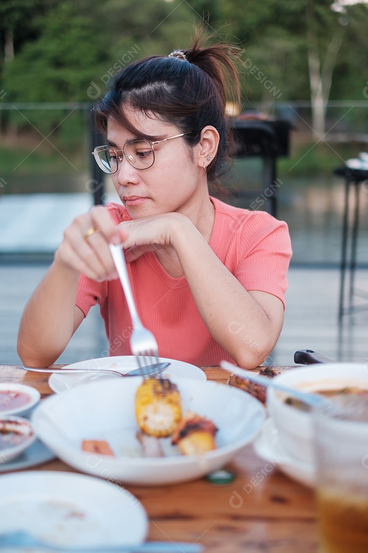 Mulher feliz jantando com deliciosas carnes grelhadas e churrasco ao ar livre. Churrasco, festa, estilo de vida e conceito de piquenique