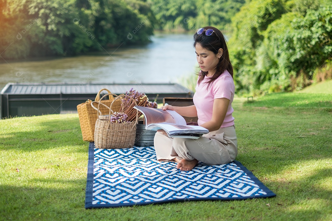 Mulher feliz com chapéu na hora do piquenique no parque perto do rio, verão, primavera e conceito de férias