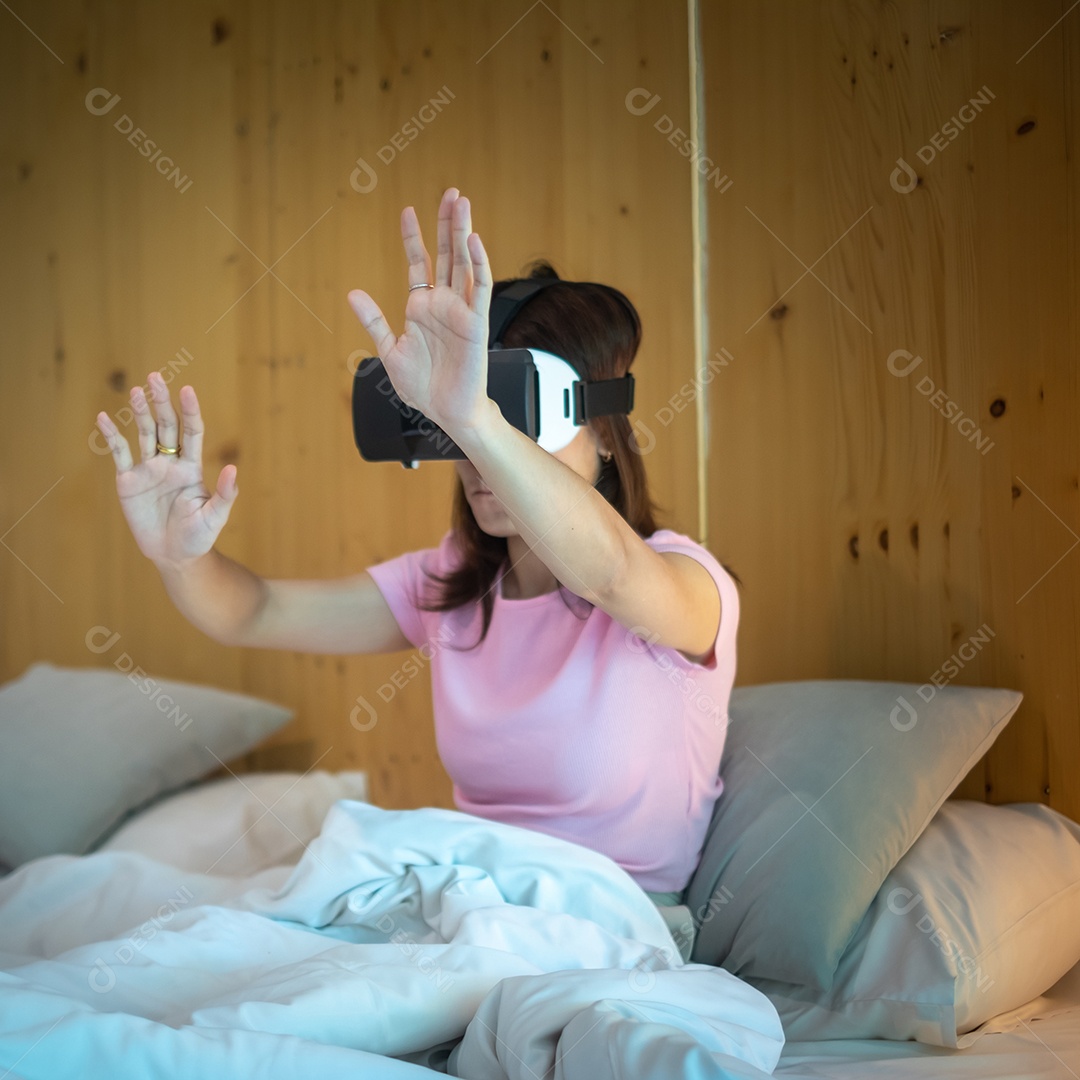 Jovem mulher usando fone de ouvido de realidade virtual na cama. VR, tecnologia digital do futuro, jogo, entretenimento de filmes