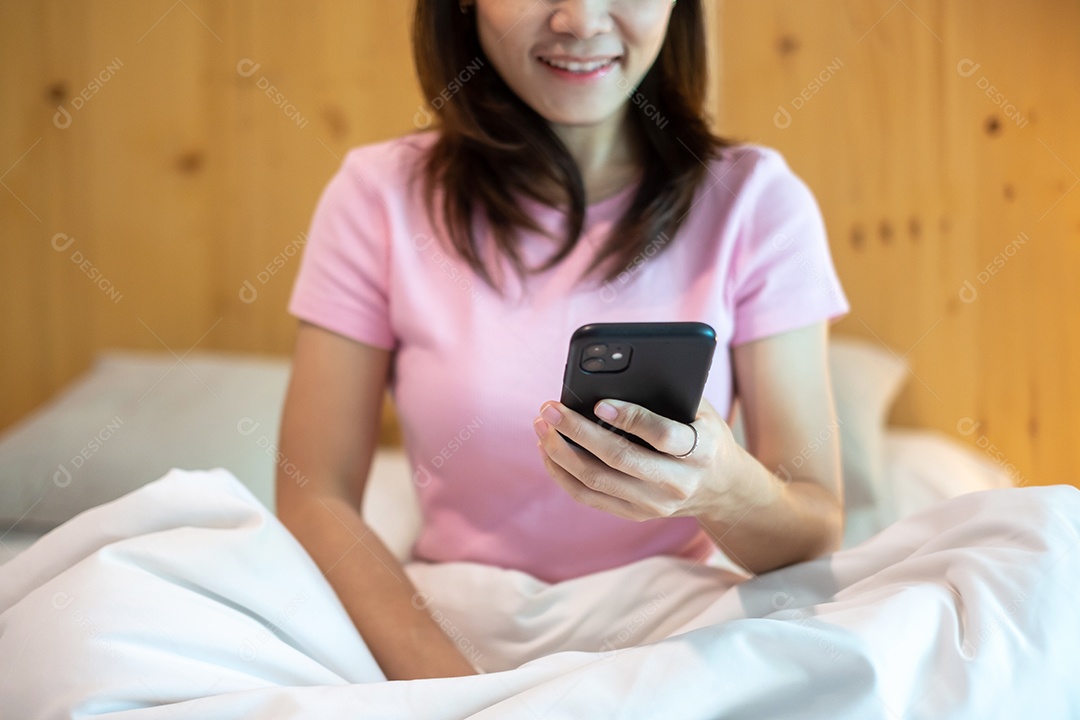 mulher usando smartphone para mídias sociais, jovem mulher assistindo filmes pelo celular na cama em casa. tecnologia, rede, compras online