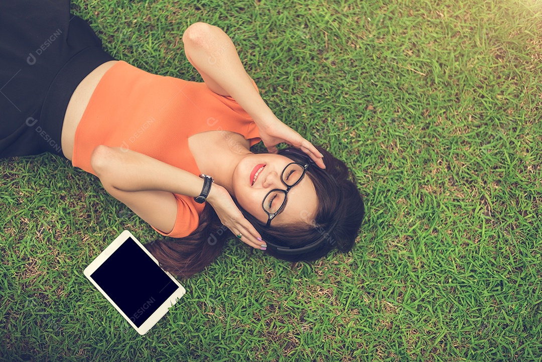 Mulher asiática ouvindo música com tablet em branco isolado preto.