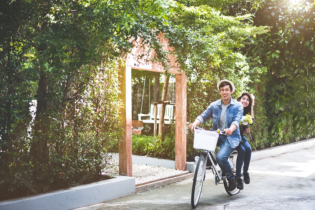 Casal feliz andando de bicicleta juntos no parque de visão romântica.