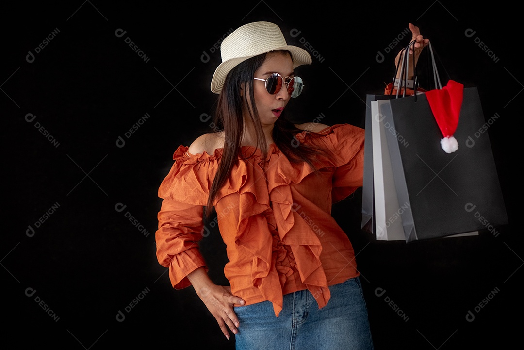 Mulher de compras asiática surpreendida com a sacola de compras Black Friday.