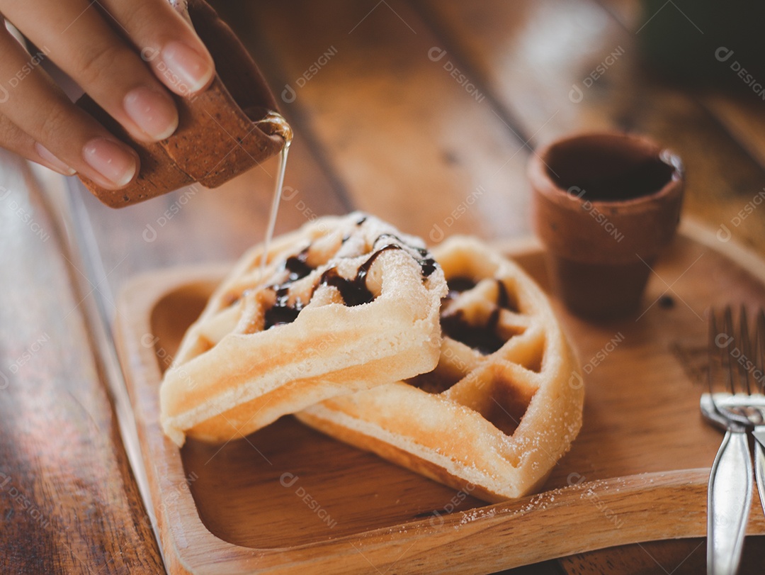 Pessoas estão derramando mel de um jarro branco na bolacha, servido com um creme virgem em uma bandeja redonda, Waffle