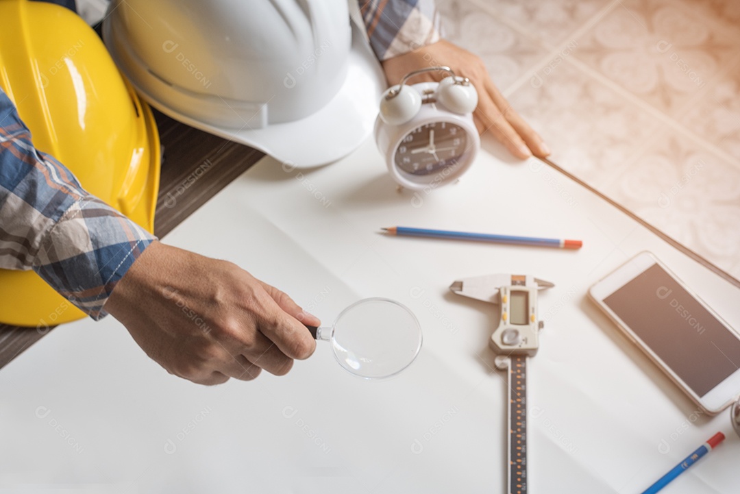 Engenheiro com lupa para procurar papel em branco para novo projeto.