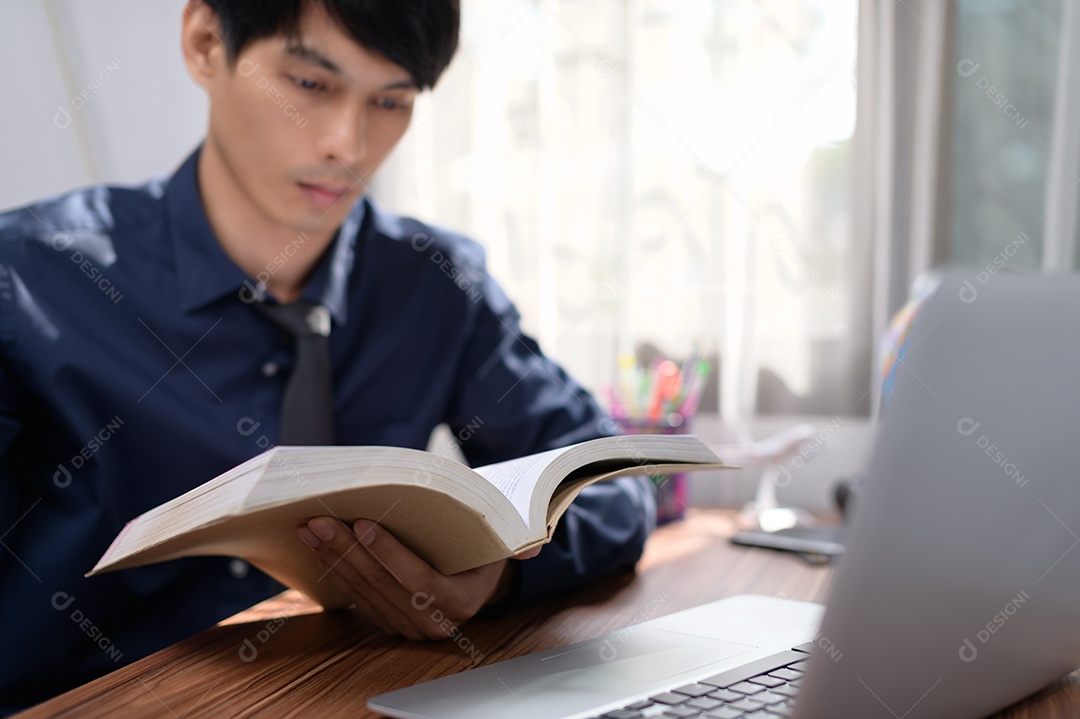 Homem de negócios lendo um livro em sua mesa