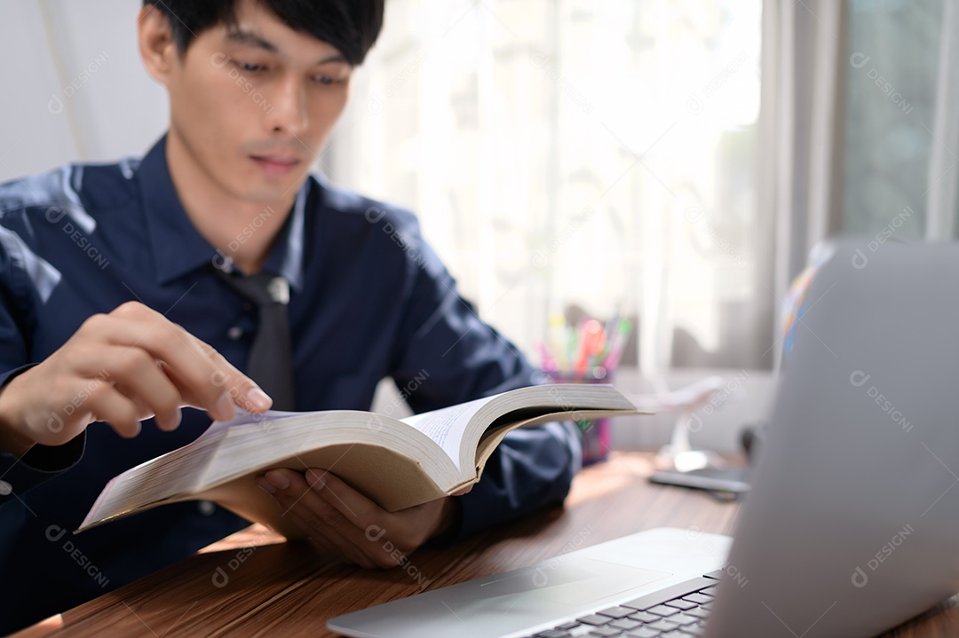 Homem de negócios lendo um livro em sua mesa