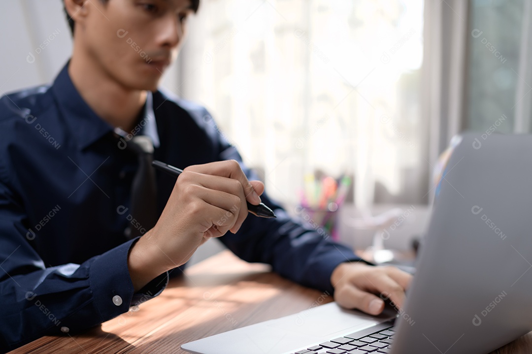 Empresário trabalhando na frente de um notebook em uma mesa