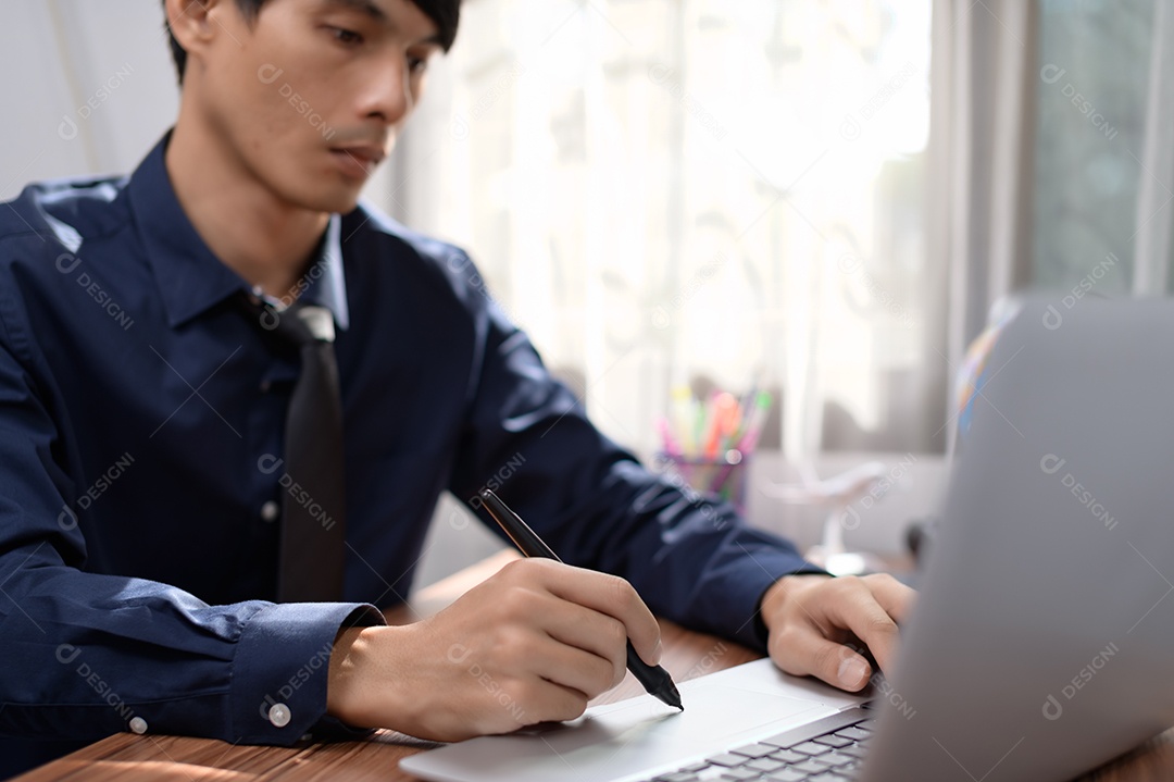 Empresário trabalhando na frente de um notebook em uma mesa