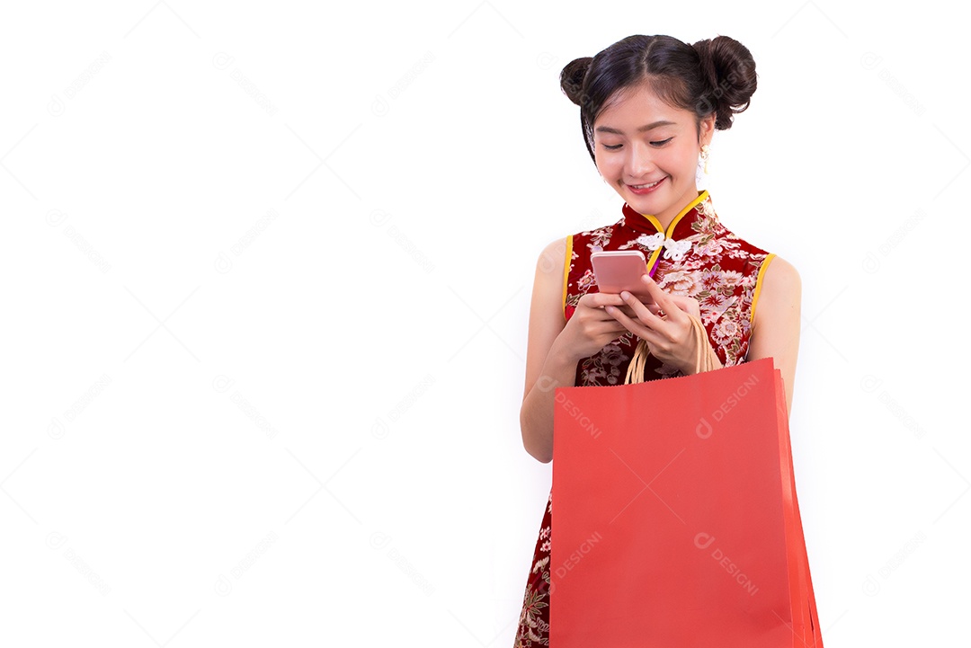 Mulher jovem de beleza asiática vestindo cheongsam e usando telefone inteligente.