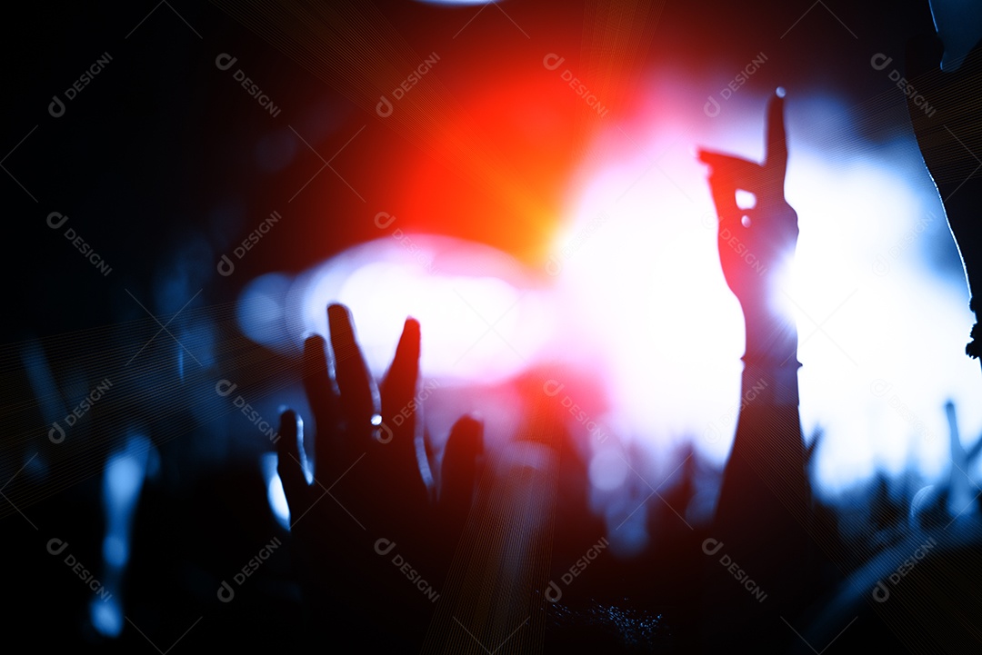 Audiência da multidão da silhueta no concerto com as mãos levantadas na música.