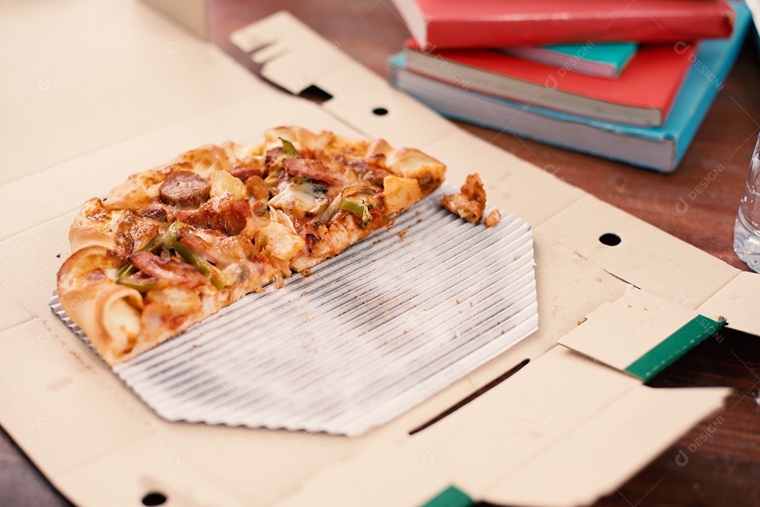 Pedaço de Pizza na mesa. Pizza na mesa com livros e bebidas.