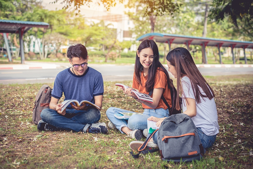 Grupo de estudantes universitários asiáticos lendo livros e aulas particulares.