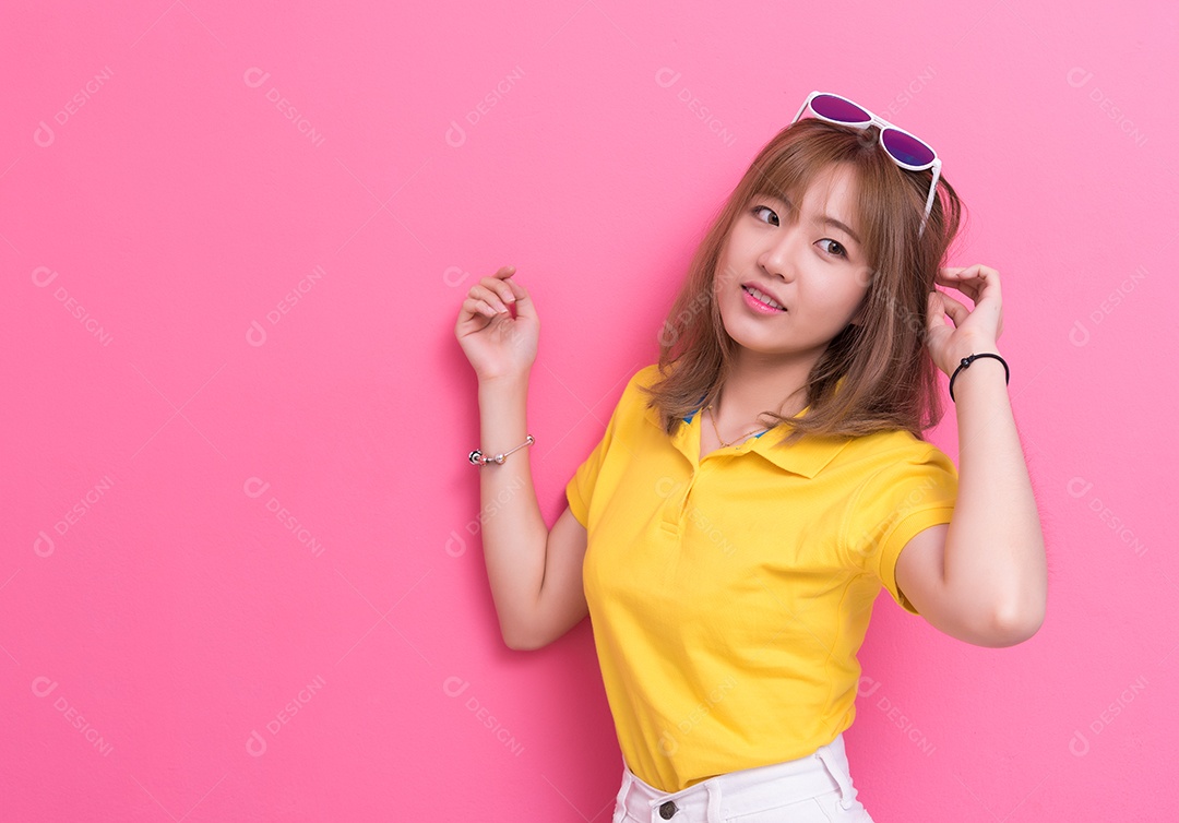 Mulher de beleza posando com óculos de sol na frente da parede rosa.