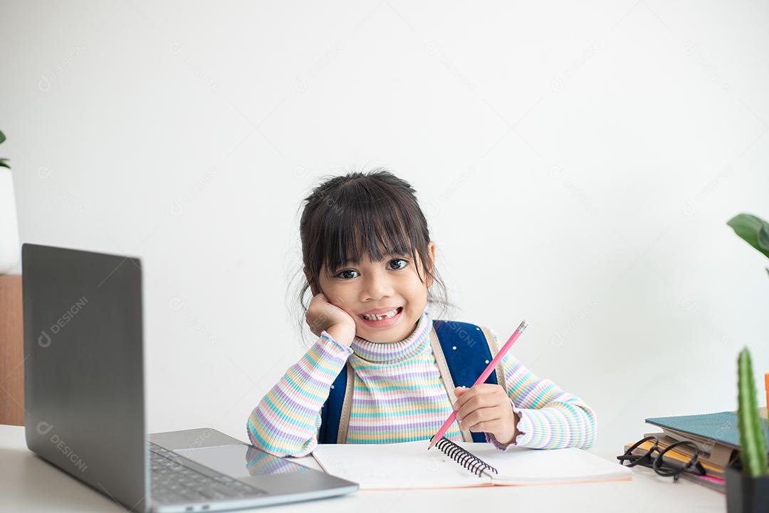 Menina asiática estudando na escola parecendo muito feliz