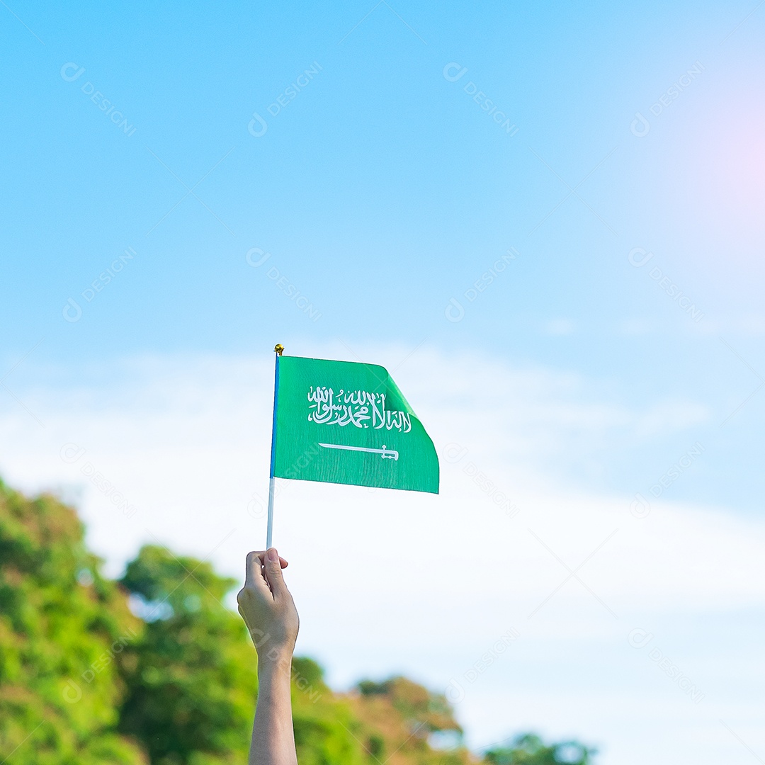 mão segurando a bandeira da Arábia Saudita no fundo do céu azul. Dia nacional da Arábia Saudita de setembro e conceitos de celebração feliz