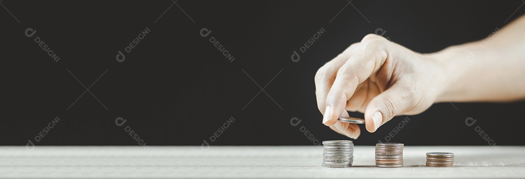 Colocar moedas à mão na pilha de moedas, poupar dinheiro e rendimentos ou ideias de investimento e gestão financeira para o futuro