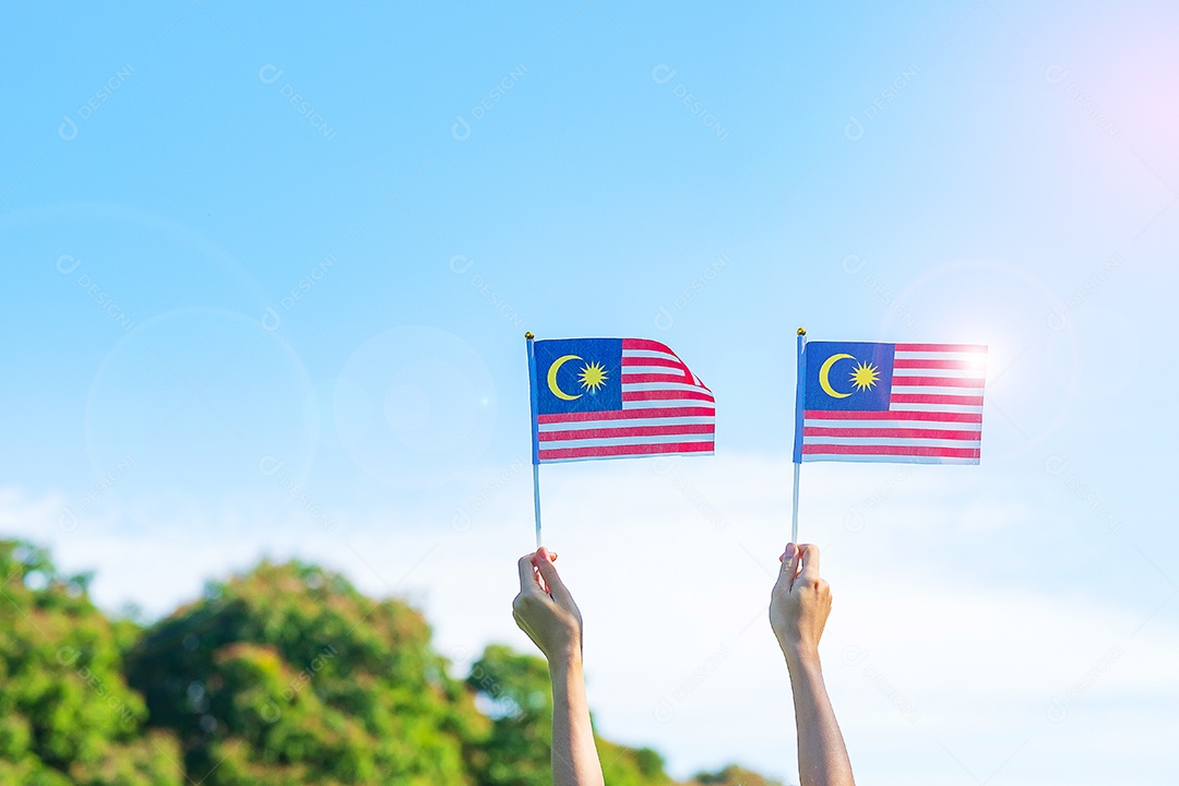 hand holding malaysia flag on blue sky background. Malaysian National Day September and Independence Day August