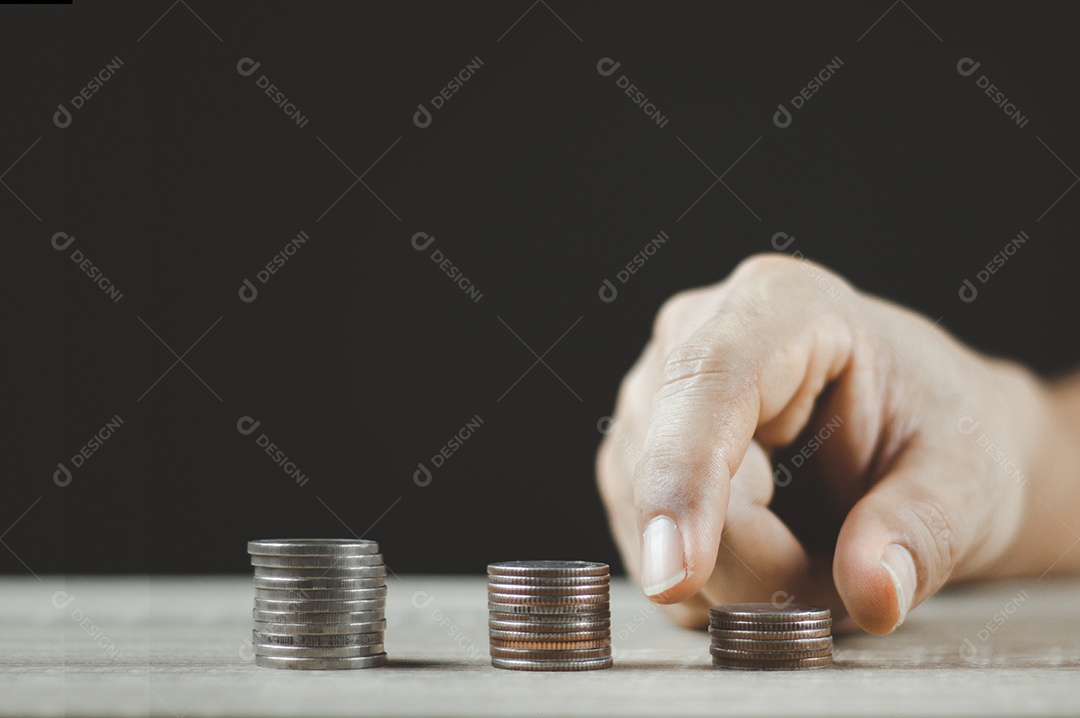 Mão masculina colocando pilha de moedas de dinheiro para o futuro negócio em crescimento