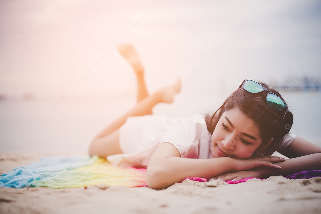 Mulher asiática de beleza tem férias na praia. Garota usando óculos de sol.