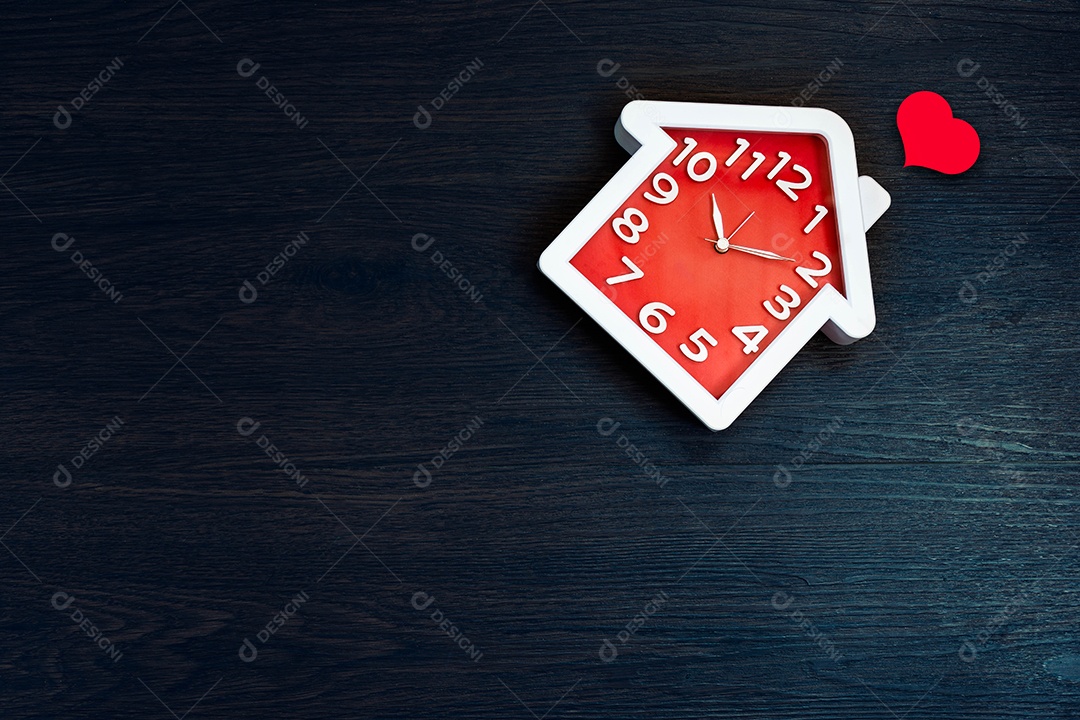 Relógio de forma em casa no fundo do chão com o ícone de um coração vermelho.
