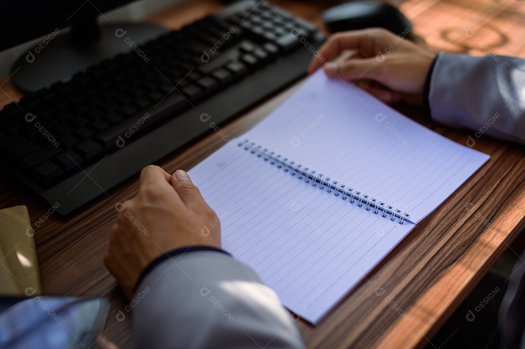 Empresário lendo e escrevendo livro no trabalho