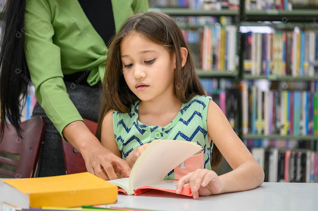 A menina pede que o professor responda à pergunta no livro enquanto lê o livro na biblioteca da escola. Conceito de educação e aprendizagem.