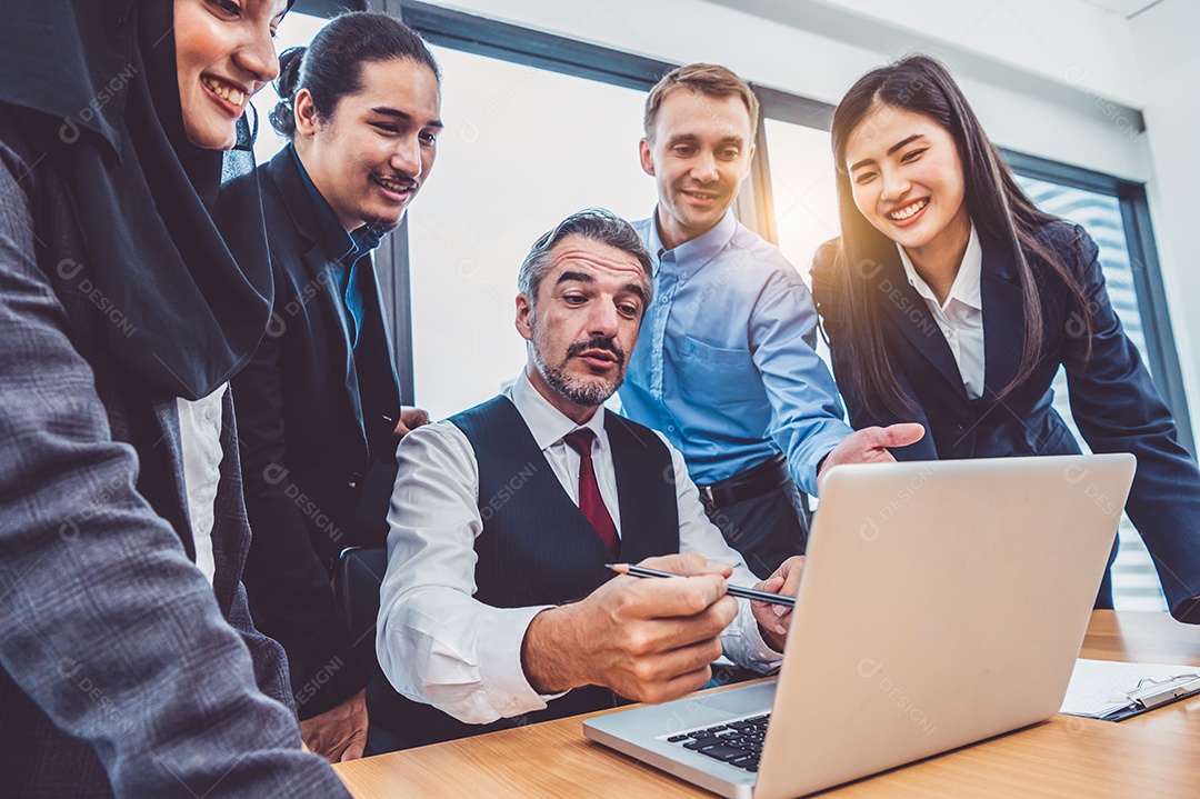 Grupo de empresários multiétnicos treinados pelo chefe executivo sênior no escritório moderno com computador portátil.