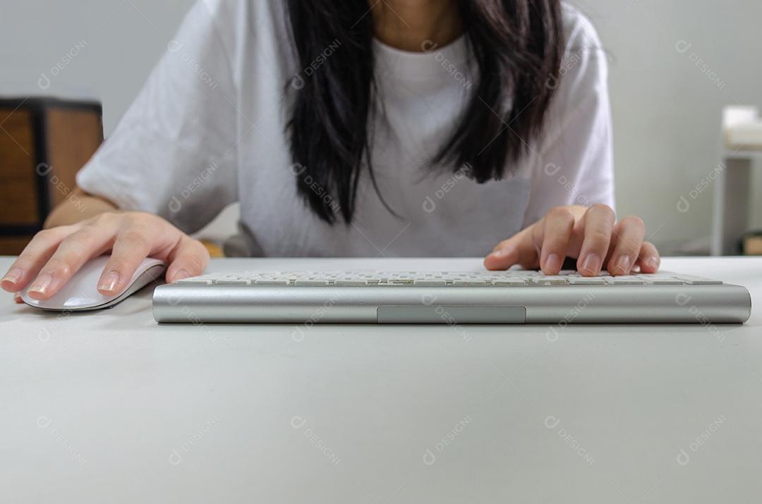 Pessoa do sexo feminino segurando o mouse e teclado de computador. Informações de internet de tecnologia navegando em mídia social on-line e conceito de rede.