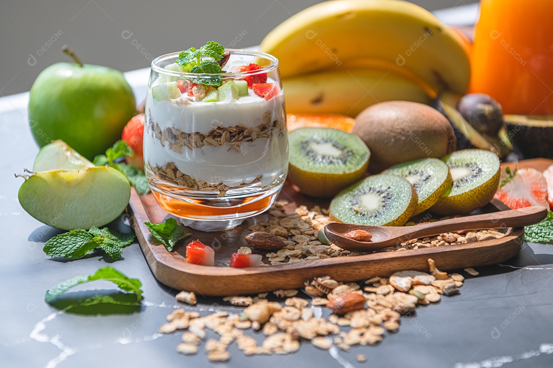 Iogurte de nutrição closeup com muitas frutas na mesa e mão do chef. Cozinha alimentar e conceito de bebidas. Tema de sobremesa orgânica.