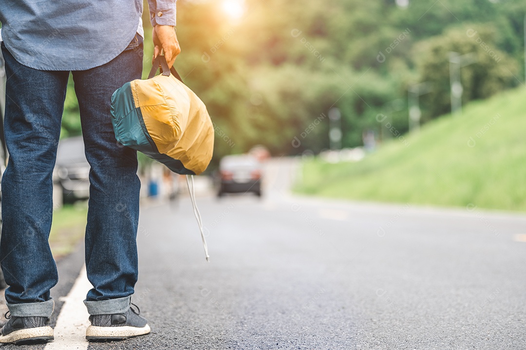 Close-up de pernas turísticas caminhando ao longo da estrada com bolsa durante a viagem no campo. Estilos de vida de pessoas e conceito de férias.