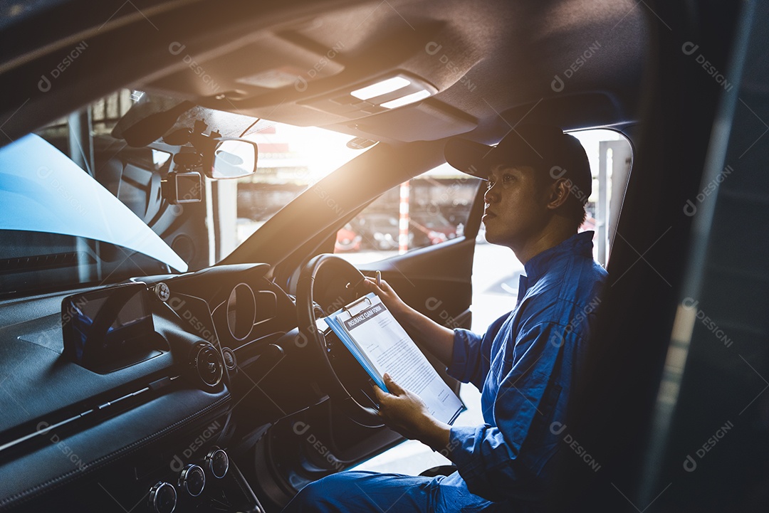 Mecânico segurando a prancheta e verificando dentro do carro para manutenção do veículo pelo pedido de reclamação do cliente na garagem da oficina mecânica.