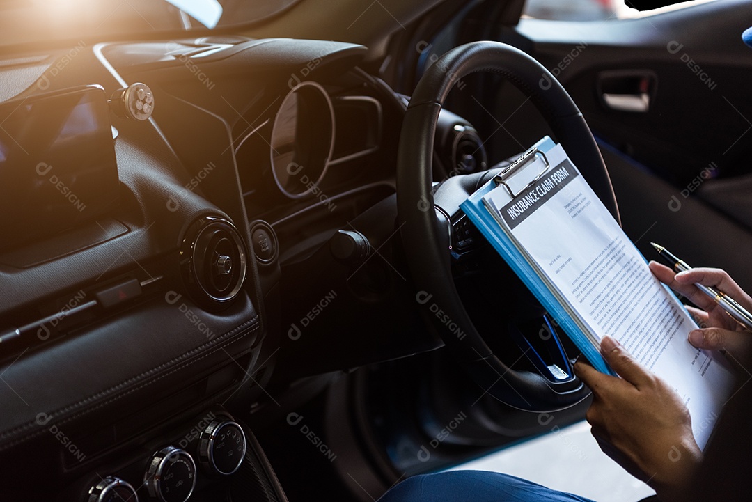 Mecânico segurando a prancheta e verificando dentro do carro para manutenção do veículo pelo pedido de reclamação do cliente na garagem da oficina mecânica.