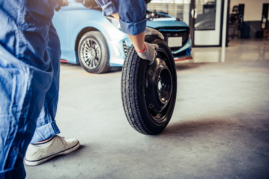 Mecânicos de automóveis trocando pneus na garagem da oficina mecânica. Conceito de trabalhadores de transporte e negócios.