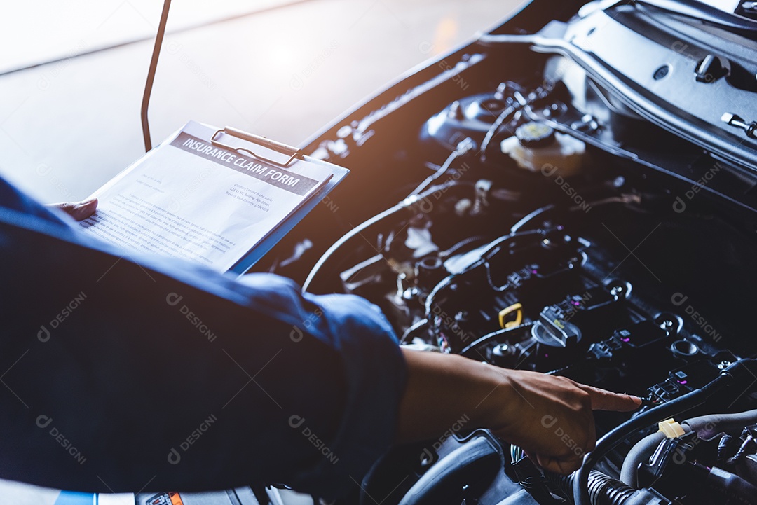 Mecânico de automóveis segurando a prancheta e verificando o veículo de manutenção pelo pedido de reivindicação de seguro do cliente na garagem da oficina mecânica.