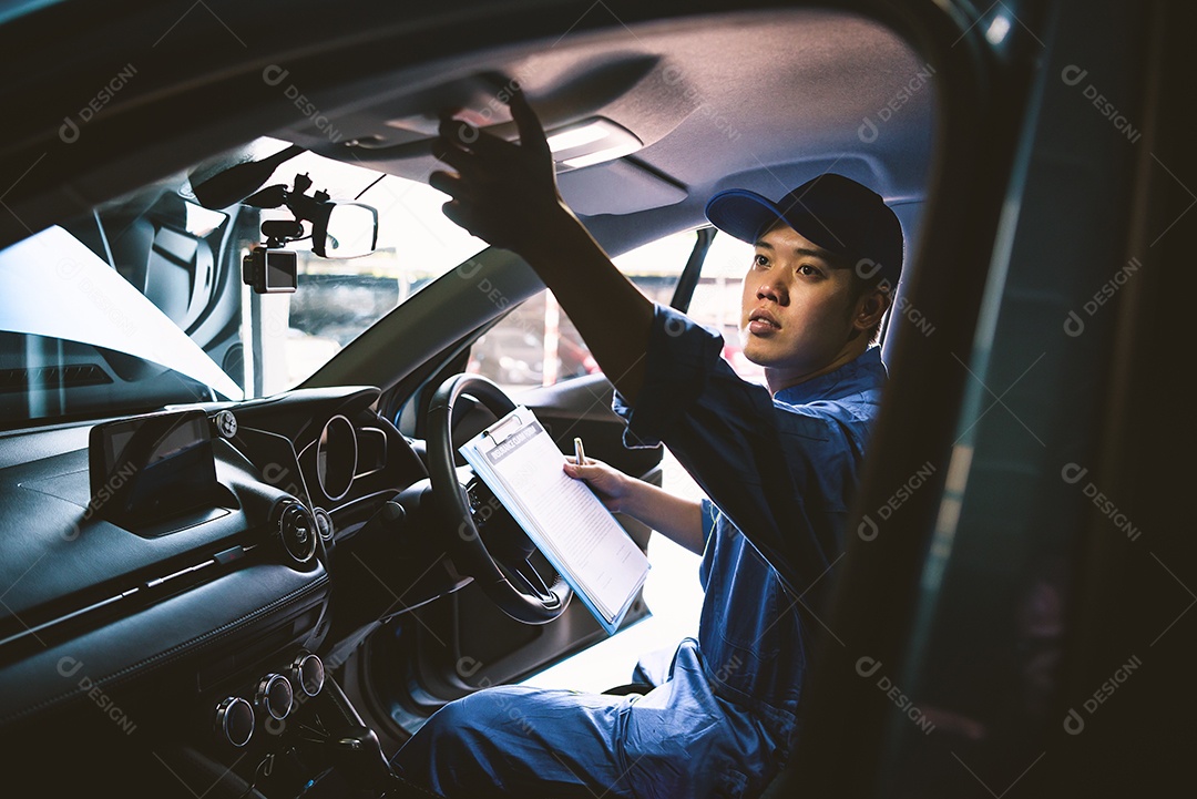 Mecânico segurando a prancheta e verificando dentro do carro para manutenção do veículo pelo pedido de reclamação do cliente na garagem da oficina mecânica.