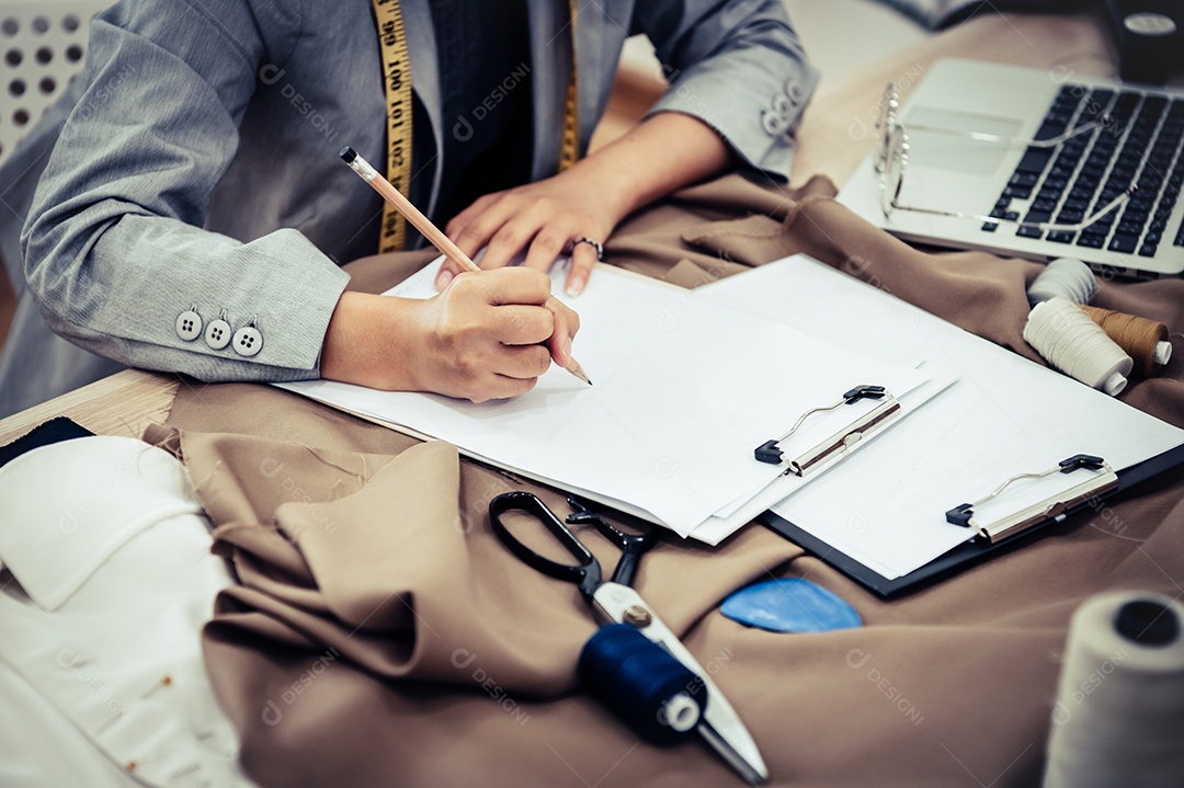 Close-up da atraente mão de designer de moda feminina trabalhando.