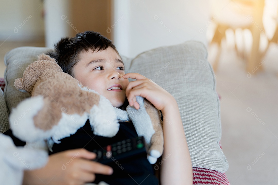 Menino feliz segurando o controle remoto e olhando para cima com um rosto sorridente