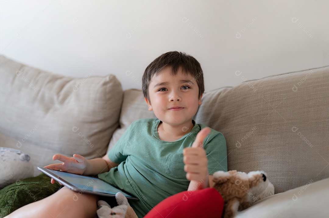 Garoto usando fones de ouvido segurando maquete de tablet