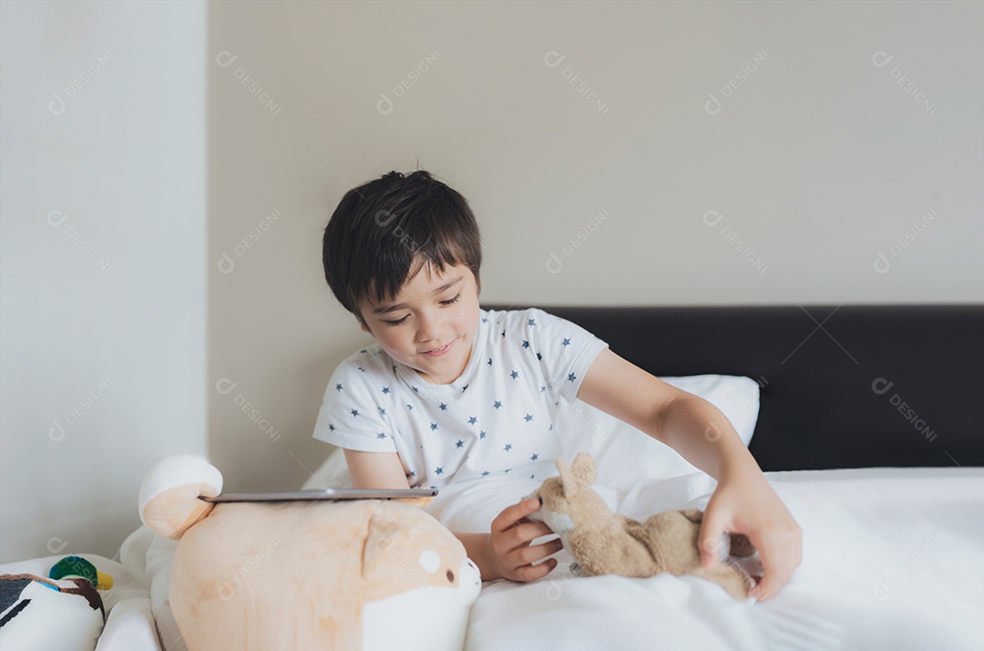 Criança brincando com brinquedo de cachorro enquanto joga online na internet no quarto