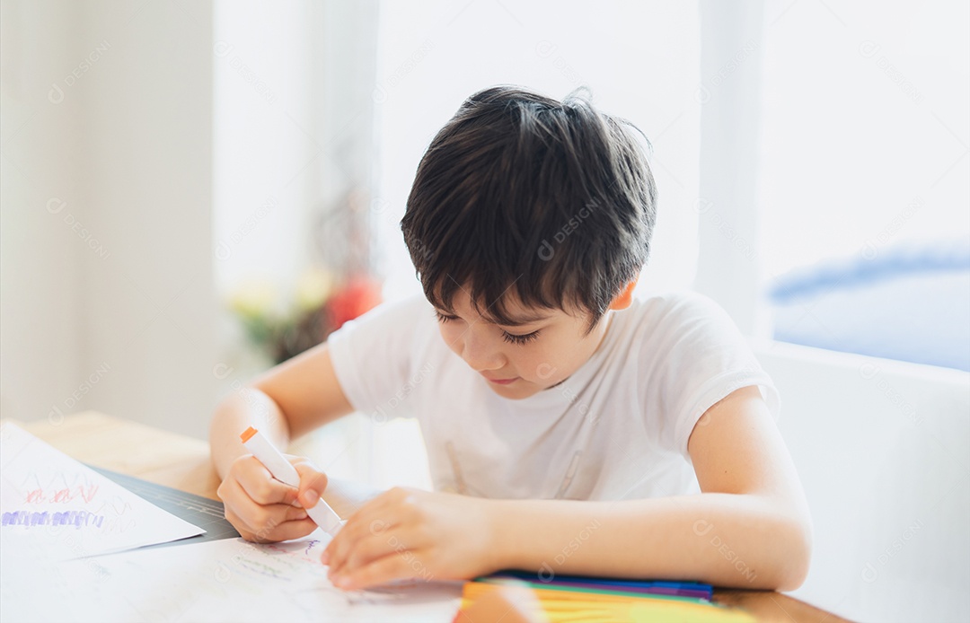 Criança da escola usando caneta colorida desenhando ou escrevendo a carta no papel