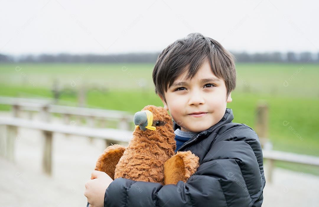 Menino feliz brincando com brinquedo de pássaro no parque na manhã ensolarada
