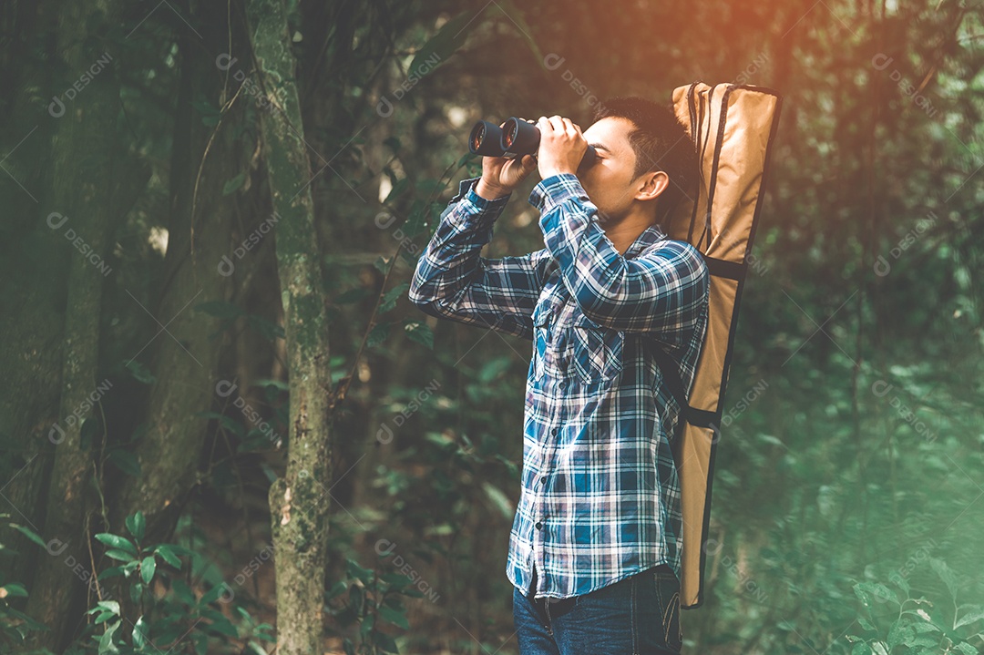 Homem com telescópio de binóculos na floresta olhando o destino.
