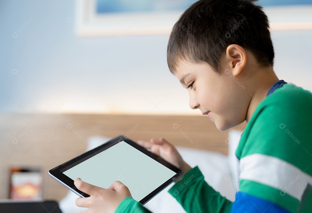 Menino usando tablet jogando jogo na internet com amigo