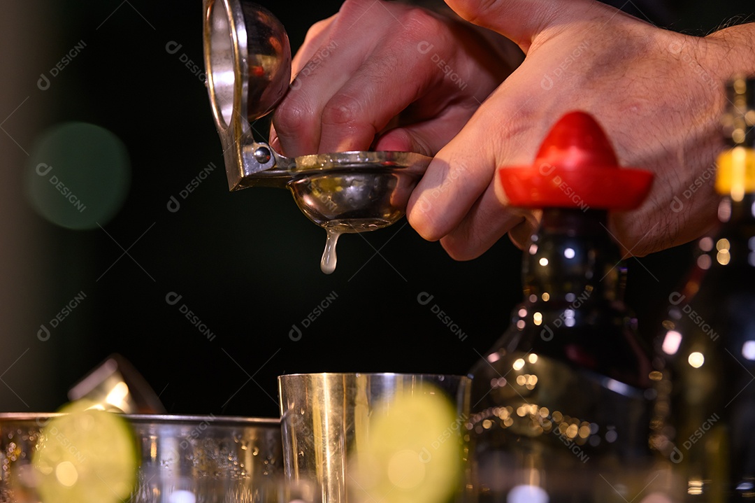 Mão de barman closeup preparando coquetel de suco fresco em beber copo de vinho com gelo no balcão de bar noturno.
